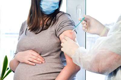 Doctor giving covid-19 coronavirus vaccine injection to pregnant woman. vaccination pregnant woman