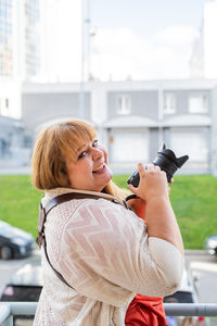 Portrait of a smiling young woman holding car