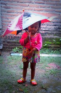 Full length of cute girl standing on rainy day