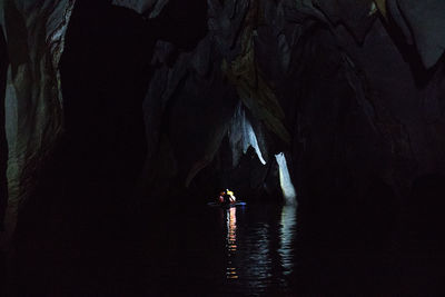 Man sailing boat in river amidst mountain