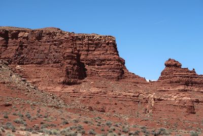 Rock formations on landscape against clear blue sky