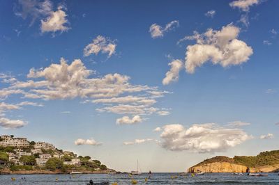 Scenic view of sea by buildings against sky