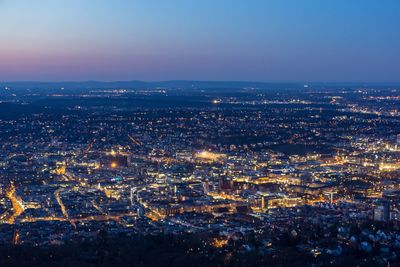 High angle view of illuminated cityscape against sky at dusk