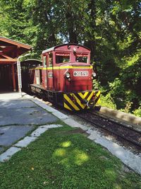 Red train on railroad track in city