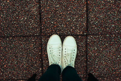 Low section of person standing on tiled floor