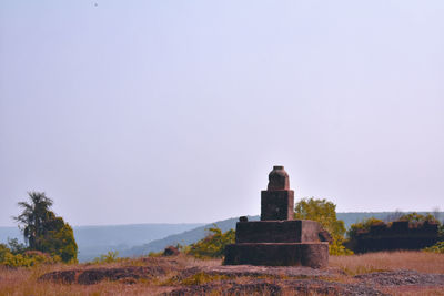 Rear view of castle sitting on field against clear sky