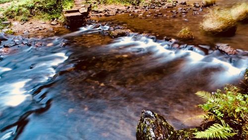 View of stream flowing through rocks