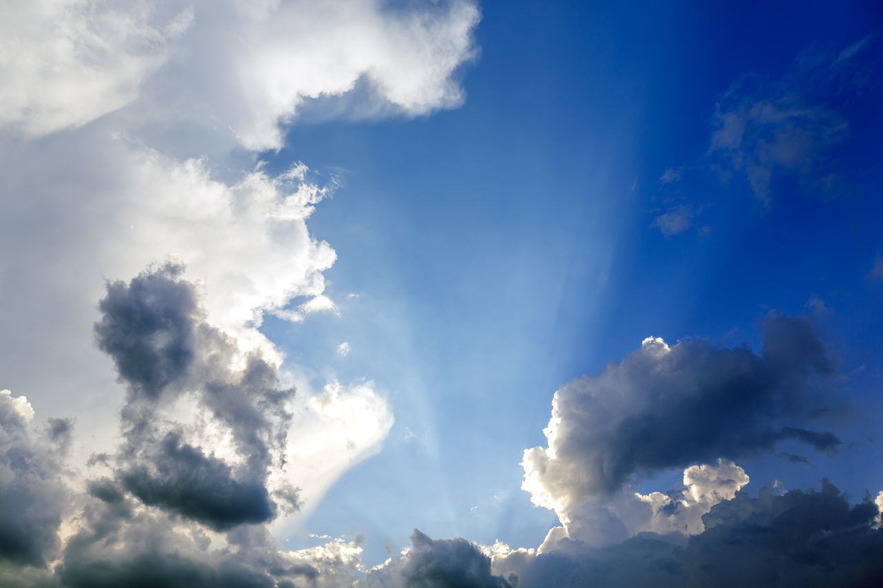 LOW ANGLE VIEW OF SUN STREAMING THROUGH CLOUDS