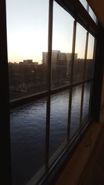 Buildings and river seen through glass window