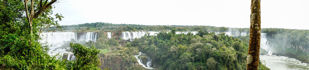 Panoramic view of waterfall in forest against sky