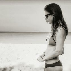 Woman standing at beach against sky