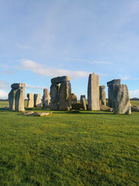 The incredible stonehenge monument with green meadow and blue sky in salisbury, england