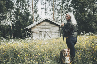 Woman with dog on street amidst trees