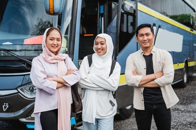 Portrait of smiling friends standing in car