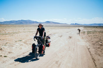 MEN RIDING MOTORCYCLE ON DESERT