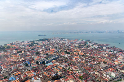 High angle view of townscape by sea against sky