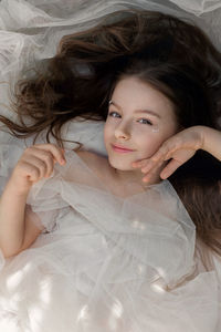 Portrait of woman lying down on bed