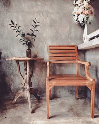 Empty chairs and table against wall in building