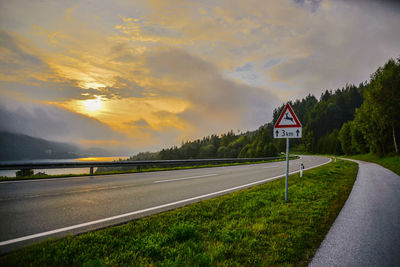 Empty road against cloudy sky