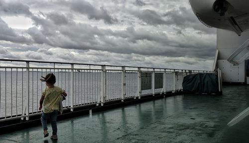 Man standing on bridge against sky