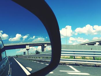 Close-up of road by bridge against sky