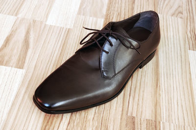 Close-up of leather shoe on hardwood floor