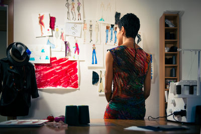 Rear view of woman standing at table in office