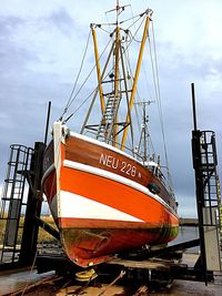 Close-up of ship moored at harbor against sky