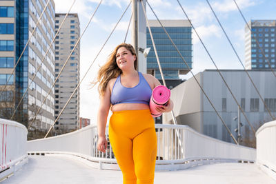 Young woman in sports clothing on footbridge