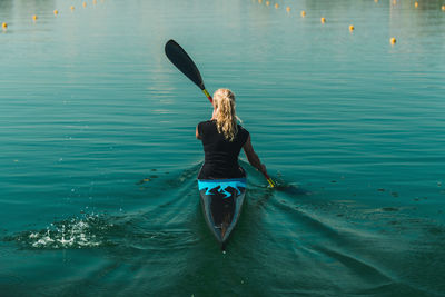 Rear view of woman kayaking in lake