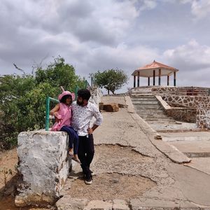 Woman with arms raised against sky
