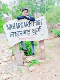 Portrait of man standing by sign board