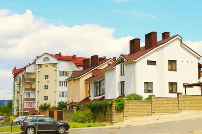 Cars parked by building against sky