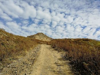 View of empty road against cloudy sky