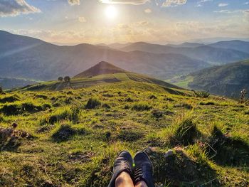 Low section of person on mountain against sky