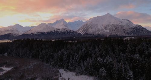 Scenic view of snowcapped mountains against sky during sunset