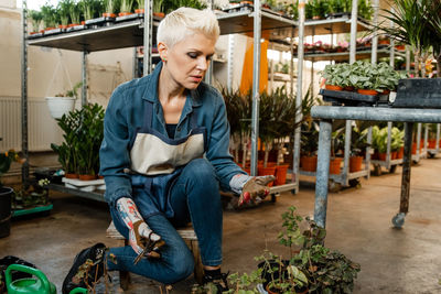 Portrait of smiling young woman standing in greenhouse