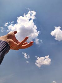 Midsection of person holding umbrella against sky