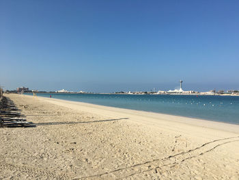 Scenic view of beach against clear blue sky