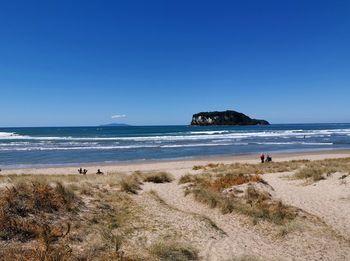 Scenic view of beach against clear blue sky