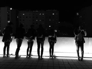 People standing in illuminated city at night