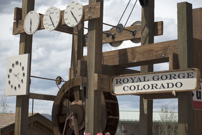 Close-up of text hanging on wood against sky