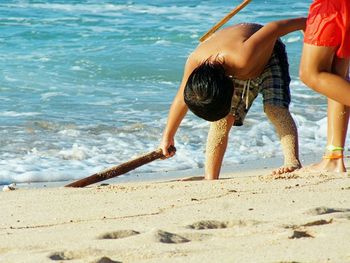 Rear view of boys standing at beach