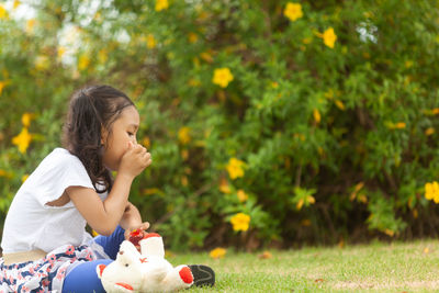 Girl looking away while sitting on grass