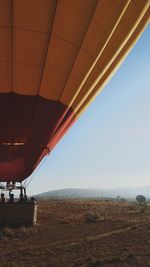 People in hot air balloon on field