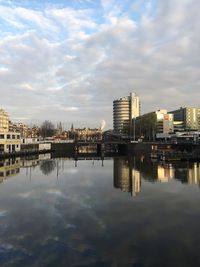 Reflection of buildings in river against sky