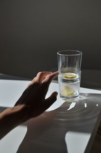 Midsection of woman holding drink on table