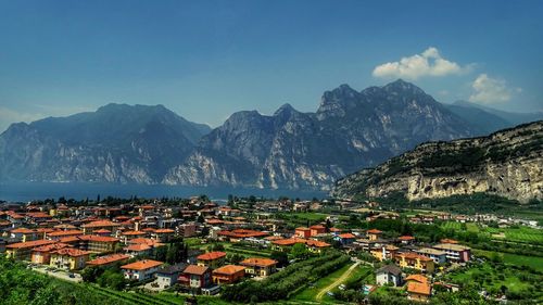 Aerial view of townscape by mountains against sky