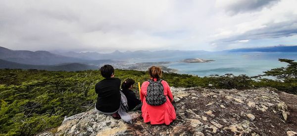 Rear view of woman looking at mountains against sky