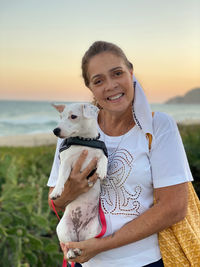Portrait of woman with dog against sky